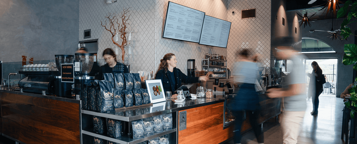 Lofty coffee bar with staff serving customers